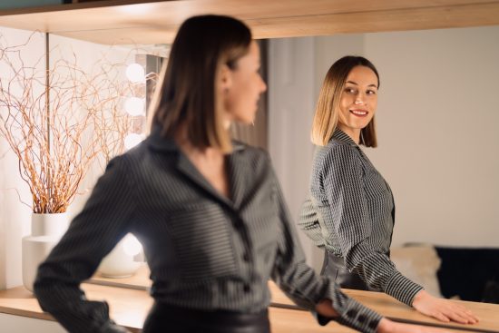 Self-confident,Woman,Looking,At,Her,Reflection,Into,The,Mirror,Indoors.